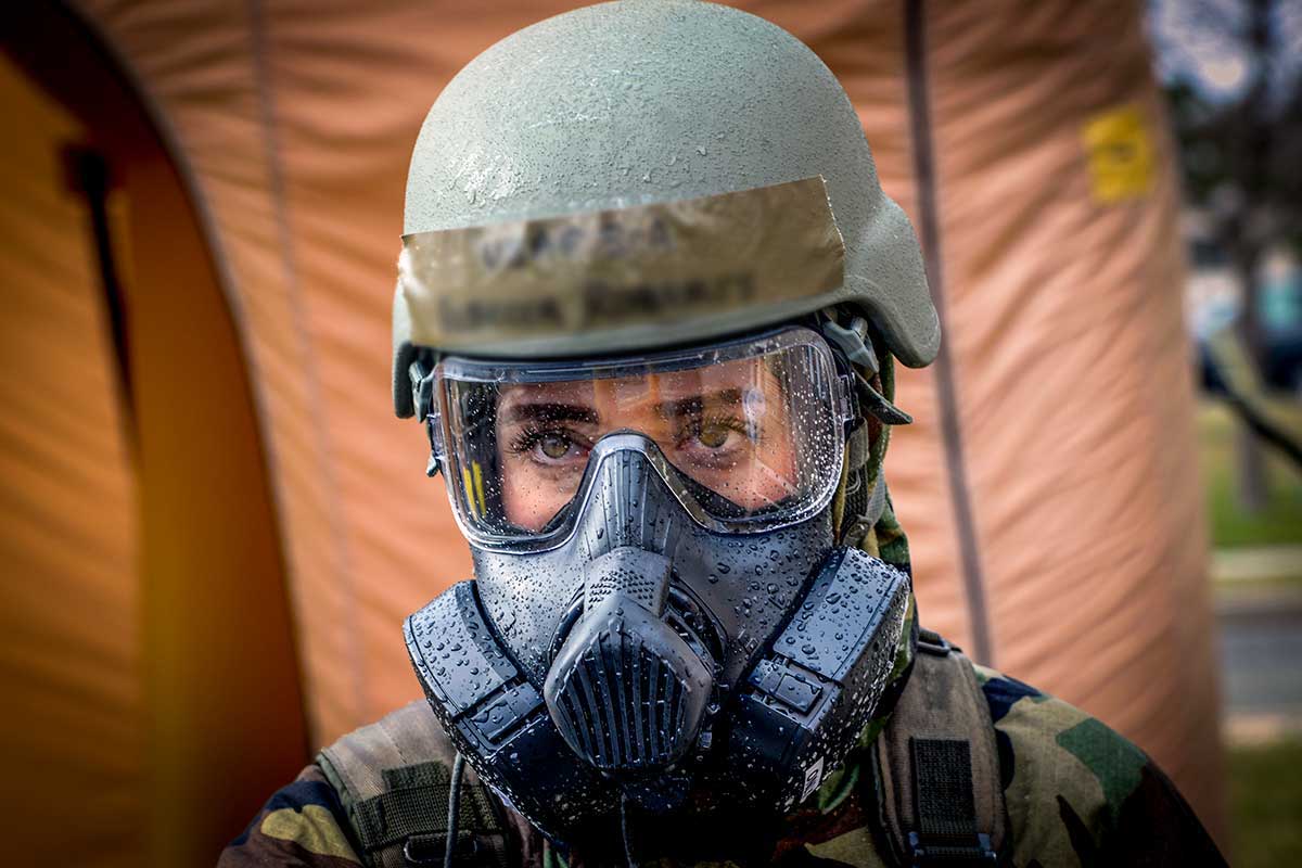 Woman wearing a gas mask Side view of combat vehicle